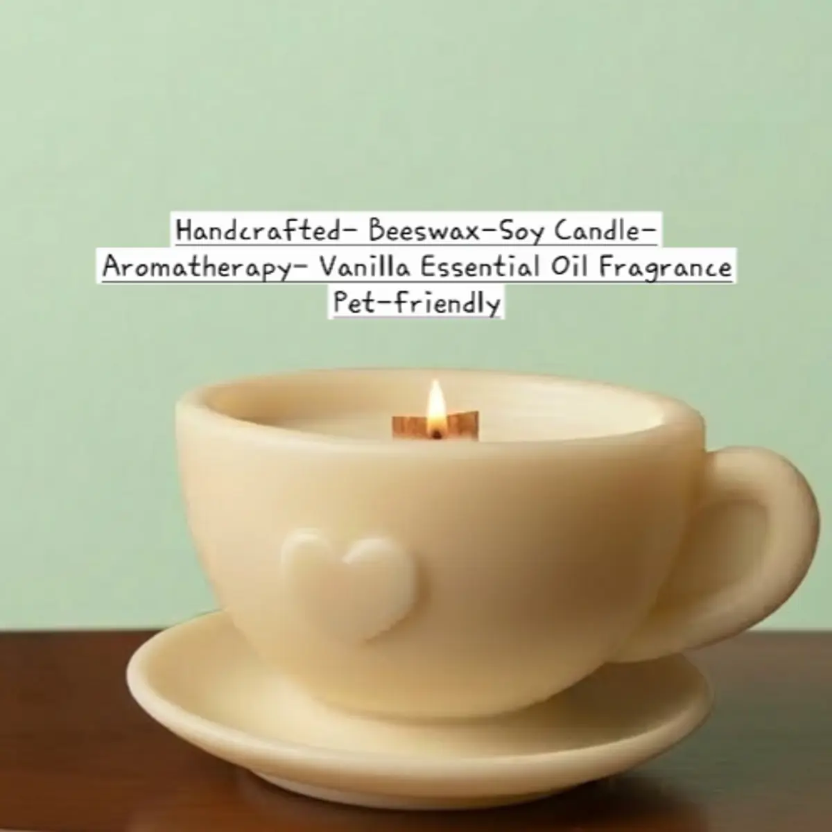 A close-up view of the artisan-made beeswax-soy teacup candle in a pale cream ivory colorway, showcasing the wooden wick flame, smooth wax surface, heart detail on the cup, and matching saucer set against a soft mint-green background. Color: Cream Ivory