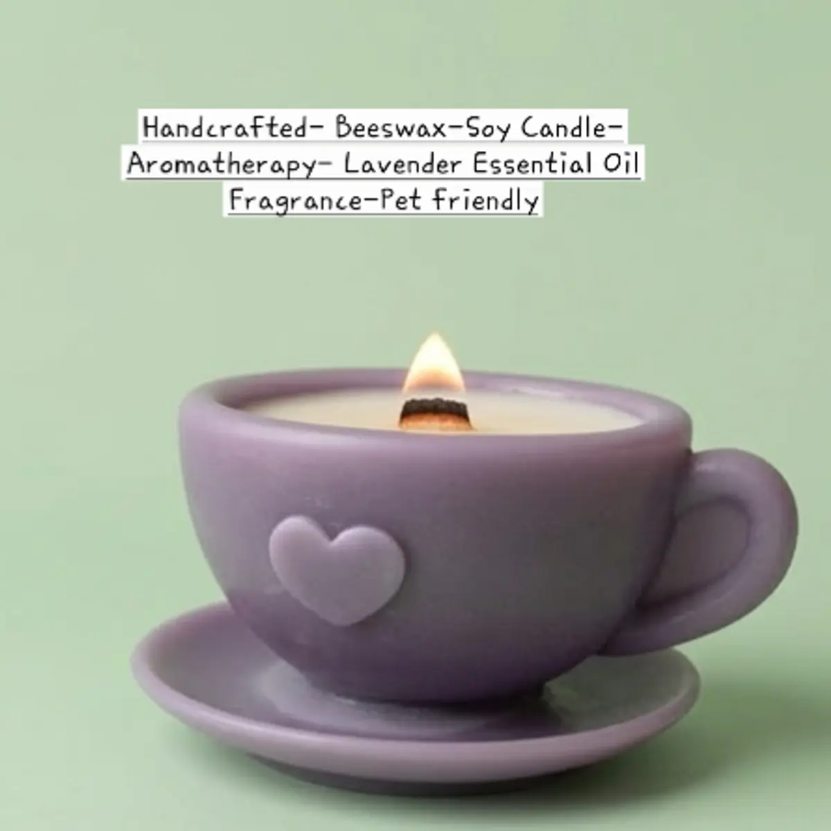 Close-up of an artisan-made beeswax-soy candle set in a matte lilac ceramic teacup and saucer with a raised heart detail, photographed against a soft sage green background with a lit wooden wick flickering gently at the center. Color: Lilac Purple