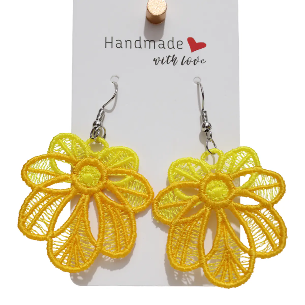 A pair of handmade yellow lace flower earrings displayed on a white 'Handmade with Love' card holder. The earrings feature an open-weave embroidered daisy silhouette in vivid golden yellow with silver fish-hook wires. Color: Yellow